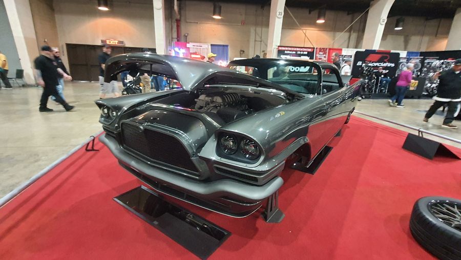 Grafitowy Chrysler 300C z 1957 roku z otwartą maską i uniesionym bagażnikiem – płetwy Exnera na czerwonym dywanie